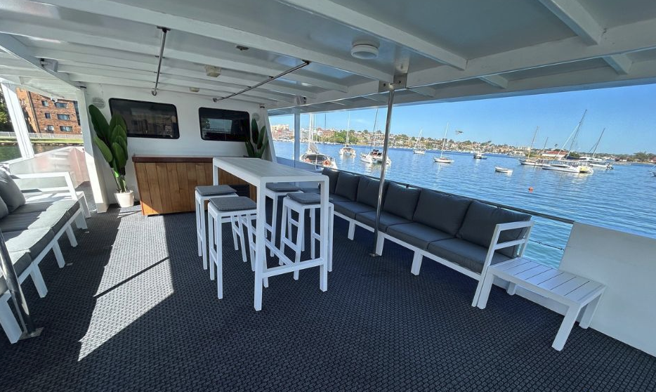 Magic catamaran interior cabin, empty, showing seating and harbour views