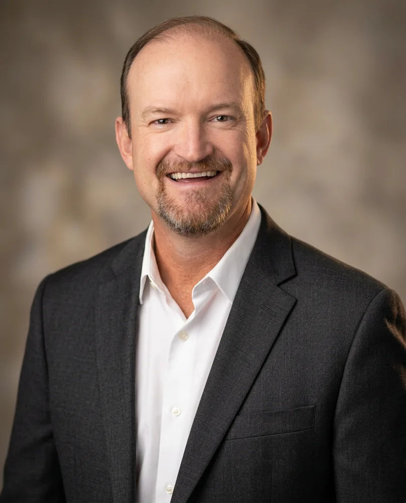 Portrait photograph of author Jim Rembach in a charcoal jacket and white shirt